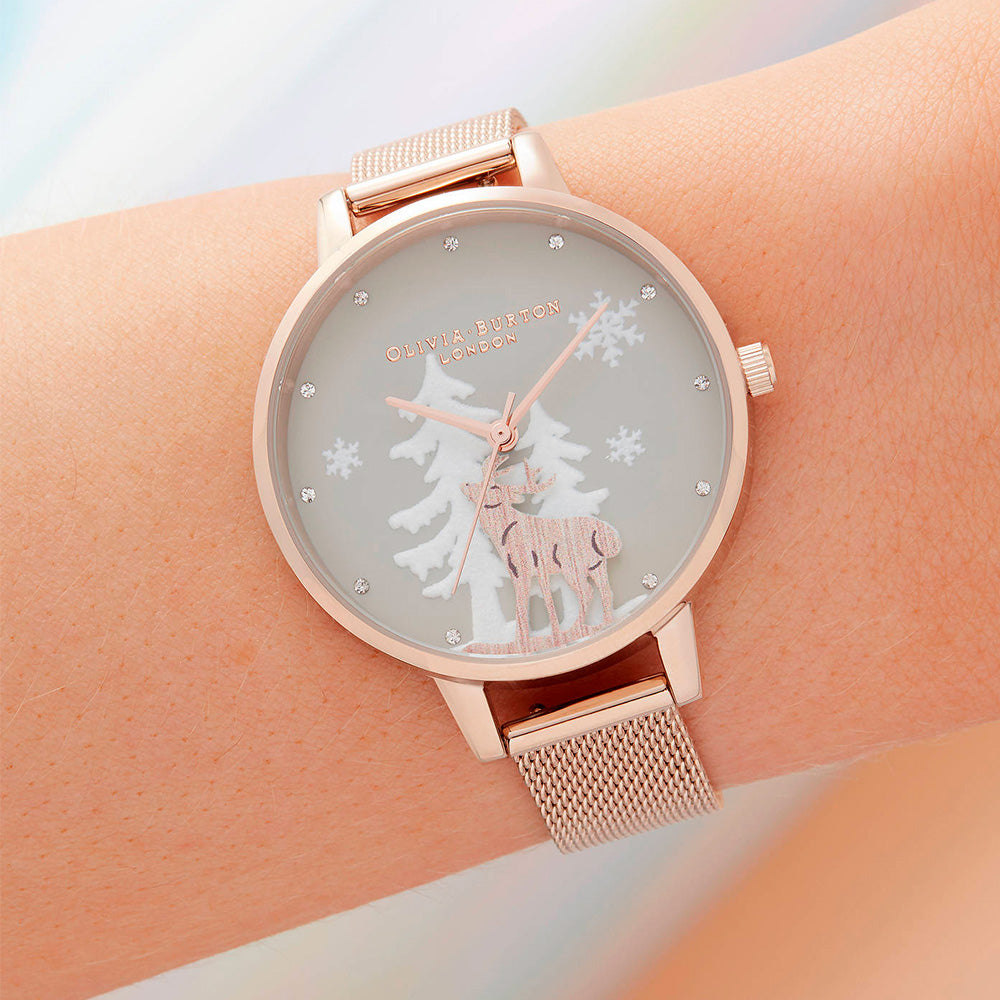 El reloj Winter Wonderland de Olivia Burton esta inspirado en la temporada de invierno, hemos introducido brillantes copos de oro rosa metálico en el dial Demi de 34 mm para crear una constelación que es toda tuya combinada con los pinos de nieve. Terminado con una correa de malla texturizada.